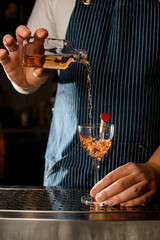 great view on wineglass decorated with heart and hand pouring drink into it
