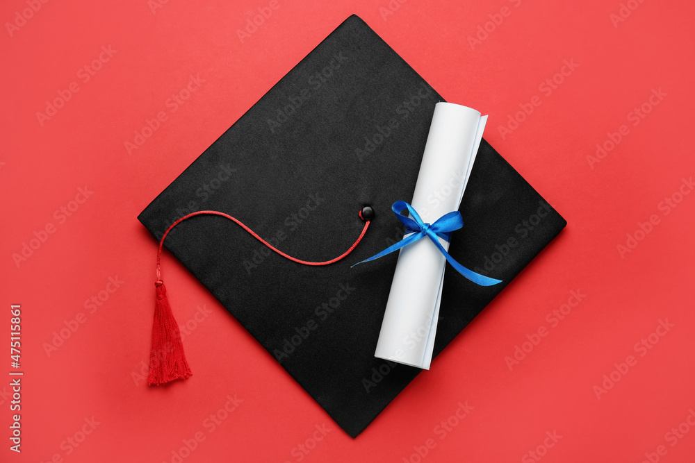 Wall mural Graduation hat and diploma on red background, top view - Wall murals