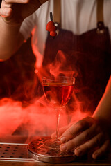 glass with drink on background of smoke with red backlight and decorative heart over it