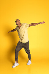 Fototapeta na wymiar Portrait of African young man in casual clothes isolated on yellow color studio background. Concept of human emotions