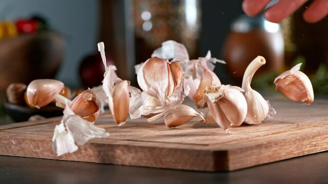 Super slow motion of rolling  garlic on wooden board. Filmed on high speed cinema camera, 1000 fps. Camera in motion control, follow the object.