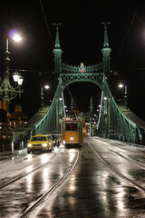 Fototapeta na wymiar BUDAPEST, HUNGARY - december 15, 2017: yellow train on Liberty Bridge or Freedom Bridge in Budapest, Hungary