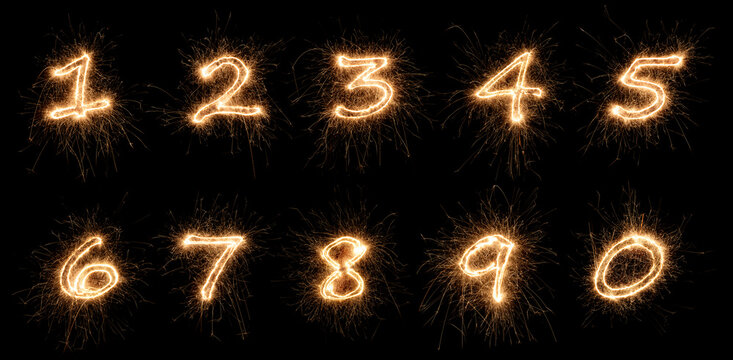 golden bright sparkler number digits font complete set collection 0 to 9 isolated dark black background. silvester new year birthday and celebration design pattern