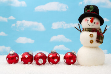 Happy snowman with hat, ornaments, and snow with sky
