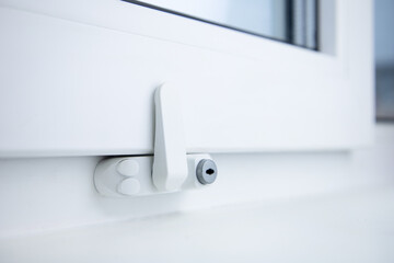 Child safety lock on a window frame an apartment . Security lock for windows ensures the safety of...