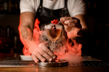 amazing view of wineglass with beverage decorated with small red hearts standing on bar with smoke around