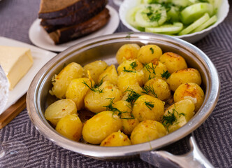 toasted young potatoes with dill in metal skillet