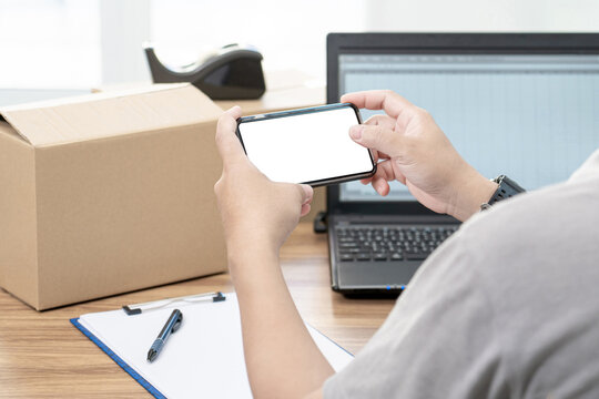 Close up hand a man use smartphone and blank white screen take photo parcel box  to store information and use laptop to register in the online system