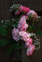 background greeting card in lilac and pink colors in dark colors with rose and valerian flowers