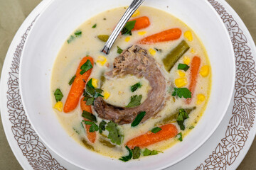 Hen soup with neck, vegetable and herb in white plate.