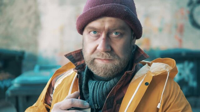 Close up of a homeless man holding a coffee cup