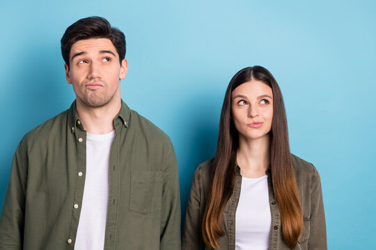 Photo of dreamy doubtful young guy woman dressed khaki shirts thinking looking empty space isolated blue color background