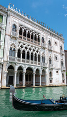 Fototapeta na wymiar Ca' d'Oro marble palace in Venice with gondola on Grand Canal