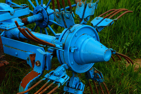Detail of a historic hay tedder decorating an orchard meadow in Hesse, Germany.