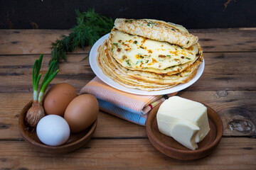 traditional Russian pancakes, blini, with green onion and egg, and butter for Maslenitsa celebration