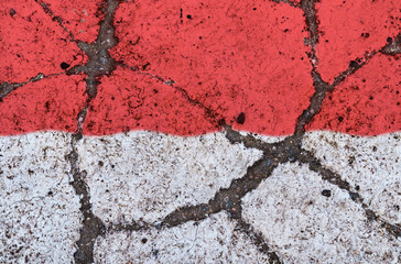 Indonesia flag on cracked asphalt. The concept of crisis, default, pandemic, conflict, terrorism. Out of focus image
