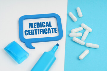 On the white and blue surface are a marker, tablets and a plate inside which the inscription - Medical Certificate