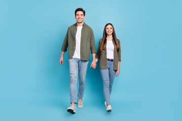 Fototapeta premium Full size photo of charming spouses lady guy hold hands stroll free time isolated over sky light color background