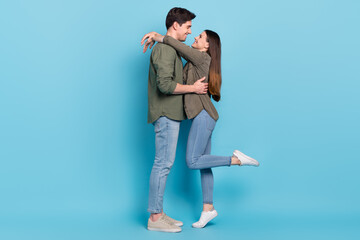 Photo of charming shiny young guy woman dressed khaki shirts smiling embracing isolated blue color...