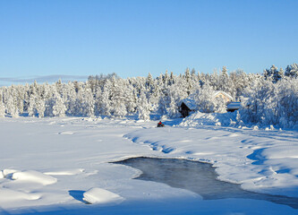 Ein Schneemobil fährt am zugefrorenen Fluss Etuväylä entlang in Muonio Lappland Finnland