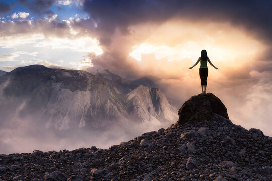 White Caucasian Adult Woman doing Yoga Pose on top of a rocky Mountain. 3d Rendering Peak. Sunset Sky. Aerial Image Background from Yukon, Canada. Adventure Sport Concept Artwork
