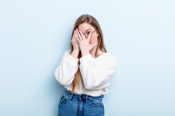 caucasian red hair woman feeling scared or embarrassed, peeking or spying with eyes half-covered...