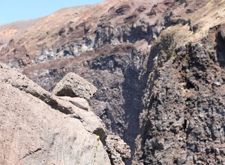 detail of the lava and in the background the crater of the dormant volcano Vesuvius near t Naples in Italy