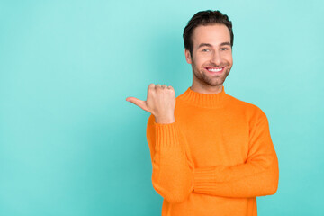 Portrait of positive satisfied man indicate thumb empty space offer isolated on teal color background