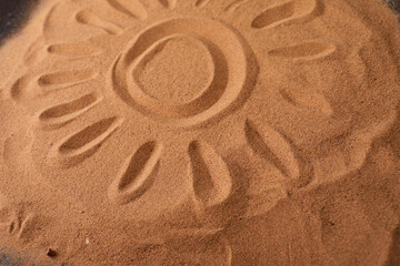 Fototapeta na wymiar .Sun Drawn in the Sand on a Beach