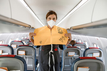 Stewardess demonstrating how to use life vest in airplane