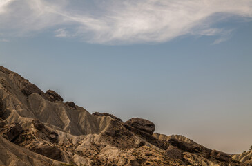 Landscape of mountain in desert of Almeria, Spain, against cloudy blue sky