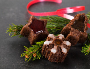 Christmas chocolate cakes cookies in the shape of a tree, snowflakes, stars with marmalade on a dark background. Close-up