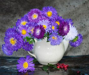 bouquet of purple asters in old teapot