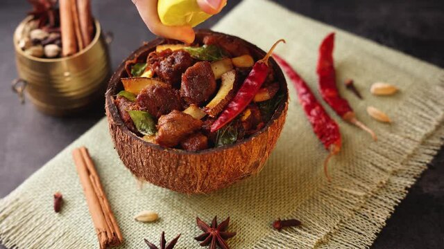 Traditional homemade Mutton curry from Asian cuisine Chukhandar gosht woman hand serving spicy meat beef curry coconut 4K video footage mutton roast Indian spices. side dish Ghee rice Appam Parotta 