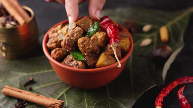 Traditional homemade Mutton curry from Asian cuisine Chukhandar gosht woman hand eating spicy meat beef curry coconut 4K video footage mutton roast Indian spices. side dish Ghee rice Appam Parotta 