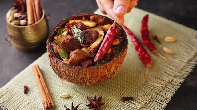 Traditional homemade Mutton curry from Asian cuisine Chukhandar gosht woman hand serving spicy meat beef curry coconut 4K video footage mutton roast Indian spices. side dish Ghee rice Appam Parotta 