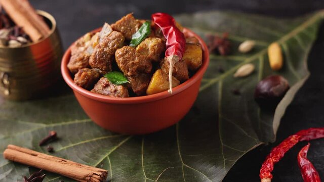Traditional homemade Mutton curry from Asian cuisine. Chukhandar gosht  woman hand serving spicy meat beef curry 4K video footage mutton roast Indian spices. side dish Ghee rice Appam Parotta Puttu