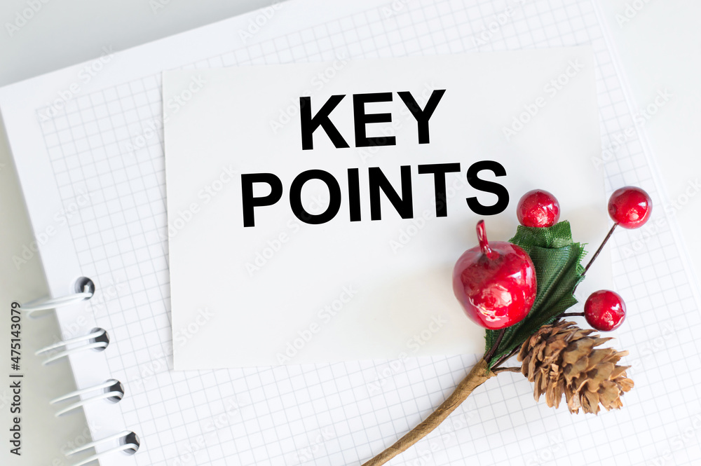 Poster key points text on a white card next to a notebook on a white table