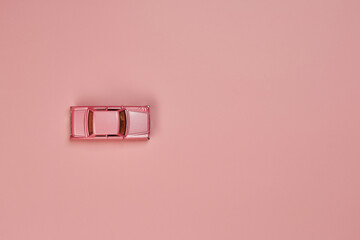 Alone micro toy small mini pink car from left to right side oriented top view isolated on the...