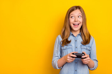 Photo of cool teenager brown hairdo girl playstation look promo wear denim shirt isolated on bright yellow color background © deagreez