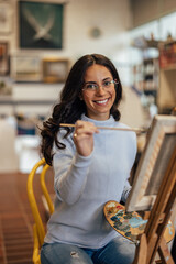 Portrait of smiling caucasian woman, enjoying her hobbies at the art studio.