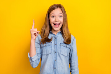 Photo of cool teen blond girl index up wear jeans cloth isolated on vivid yellow color background