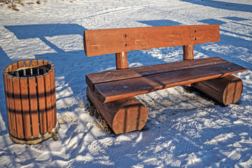Bench in the alley of the city park on a sunny winter day