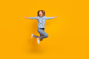 Naklejka na ściany i meble Full body photo of hooray teenager girl jump yell wear bag jeans shirt sneakers isolated on yellow background