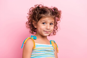 Portrait of attractive cheerful shy wavy-haired preteen girl summer season isolated over pink pastel color background
