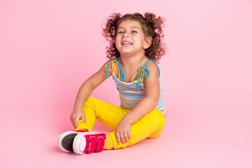 Obraz na płótnie Canvas Portrait of attractive funny cheerful wavy-haired girl sitting on floor laughing good mood isolated over pink pastel color background