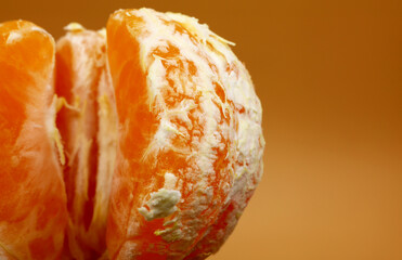 close-up of a peeled tangerine on a yellow background