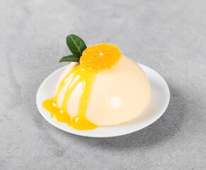 Vegan dessert, Tangerine Panna Cotta with sauce on a platte on a light gray background