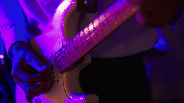 Male guitarist playing electric guitar on a rock concert or in the club. Blue red lighting. High quality 4k footage
