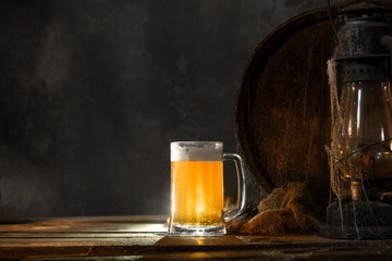 Mug with fresh light beer with foam on wooden vintage background with barrel